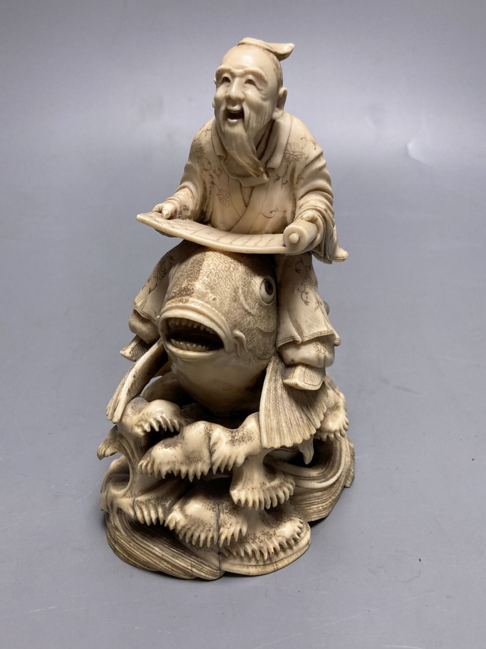 A fine Japanese ivory okimono of kinko riding a carp, 19th century, signed Ichyosen Naohide, height 15cm